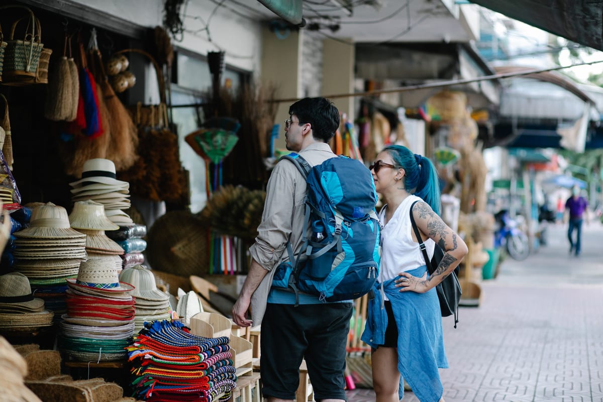 Two travelers browsing a street market