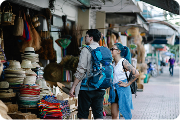 Two travelers browsing a street market
